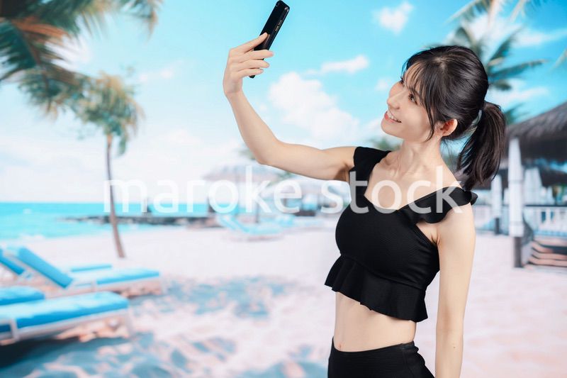 ビーチで自撮りをする若い女性