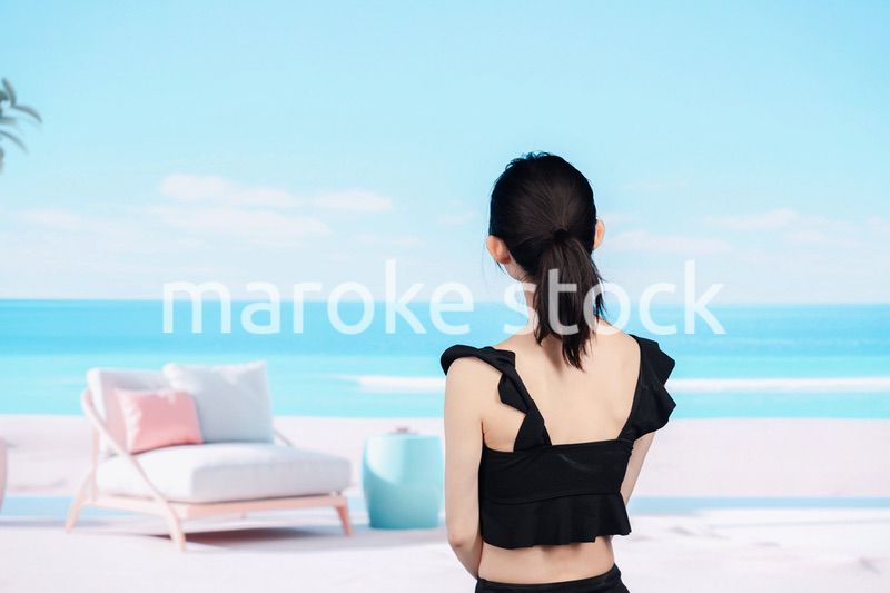 水着を着て海を眺める若い女性