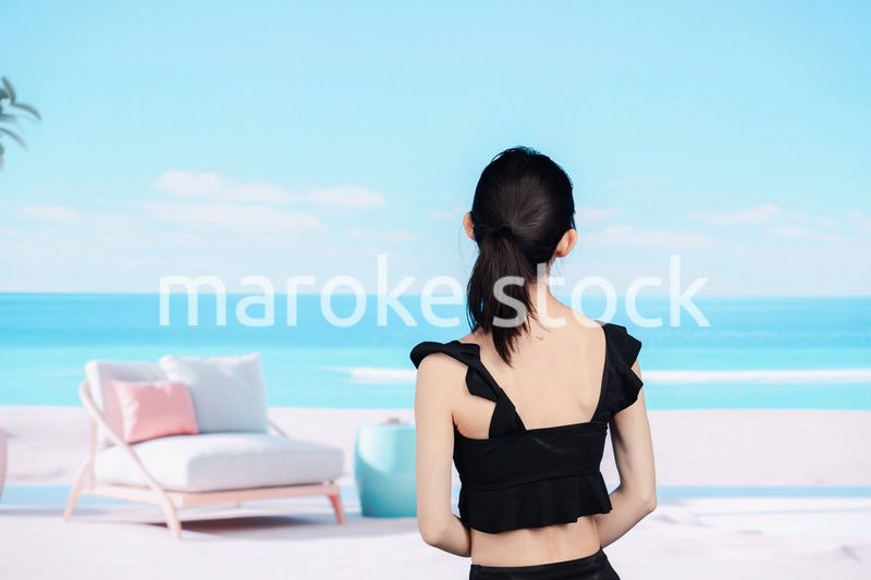 水着を着て海を眺める若い女性