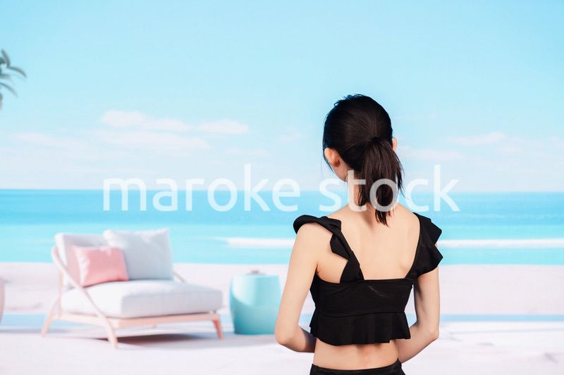 水着を着て海を眺める若い女性