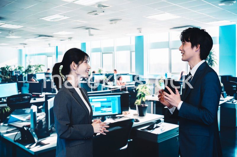 オフィスで楽しく話す男女のビジネスパーソン