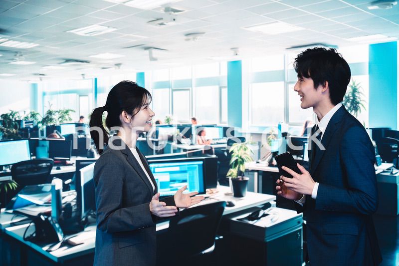 オフィスで楽しく話す男女のビジネスパーソン