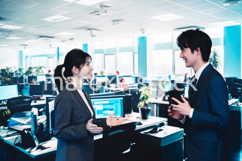 オフィスで楽しく話す男女のビジネスパーソン