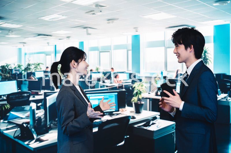 オフィスで楽しく話す男女のビジネスパーソン
