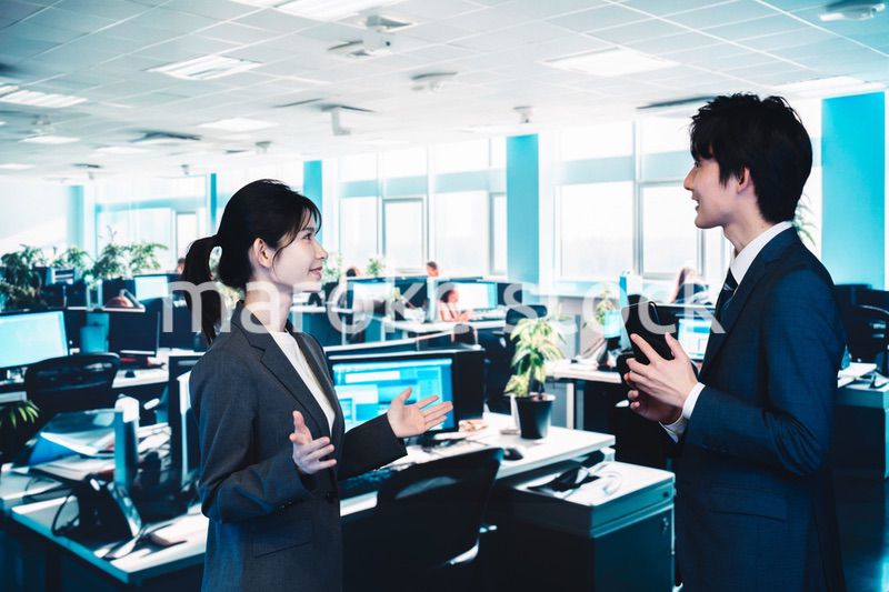 オフィスで楽しく話す男女のビジネスパーソン