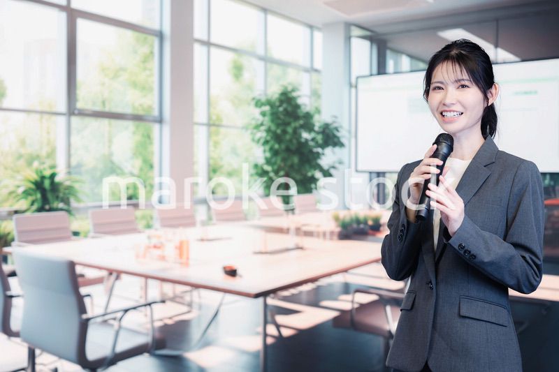 マイクで話すビジネスウーマン