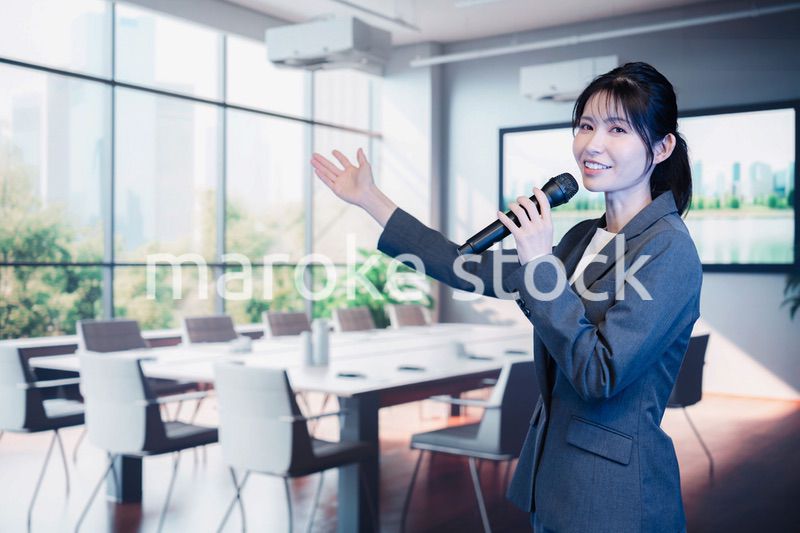 マイクで話すビジネスウーマン