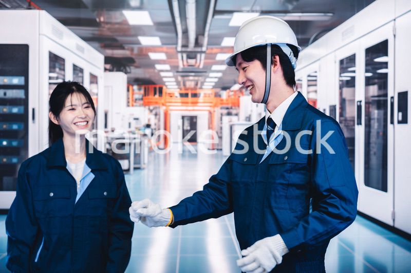 工場で楽しく働く男女の作業員