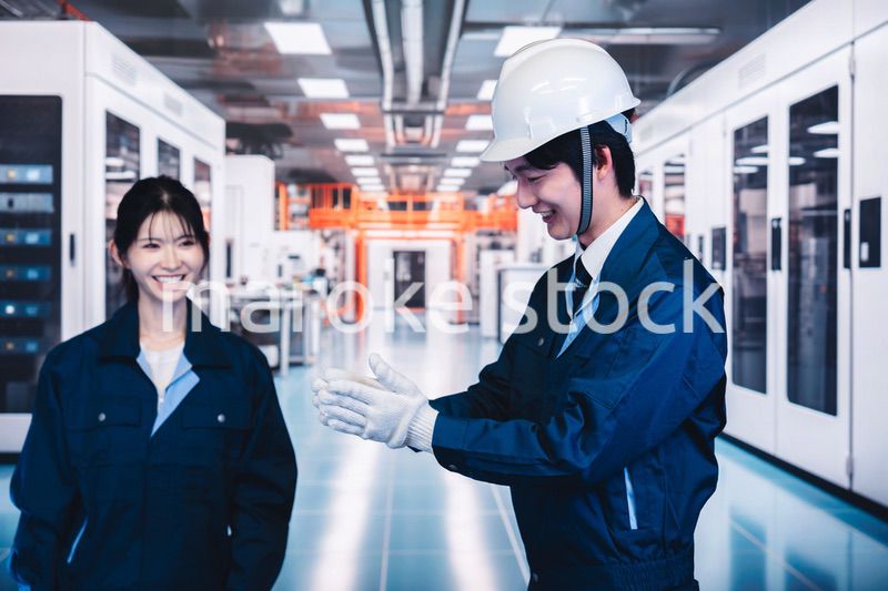 工場で楽しく働く男女の作業員