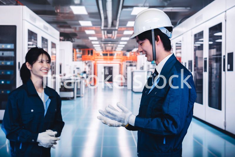 工場で楽しく働く男女の作業員