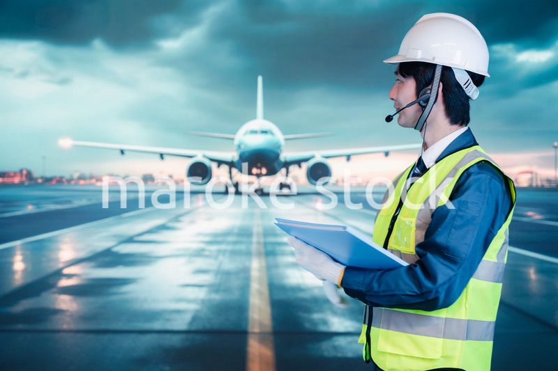 空港の滑走路上で働く若い男性