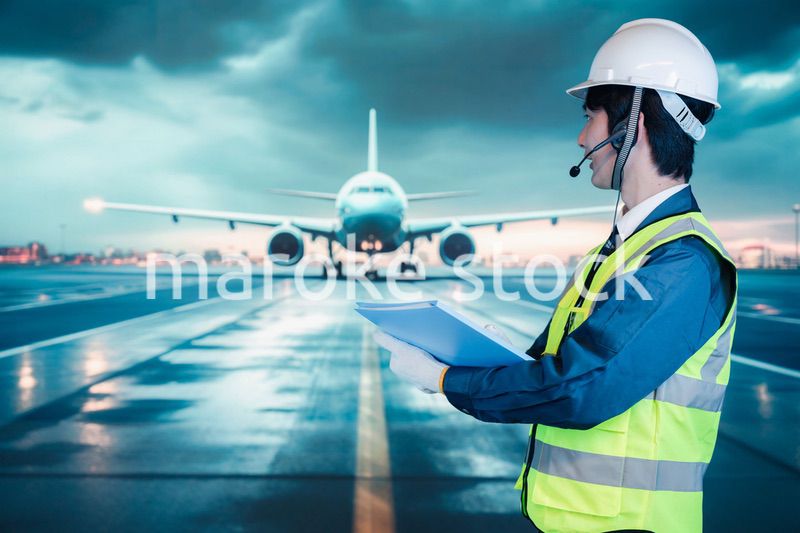 空港の滑走路上で働く若い男性