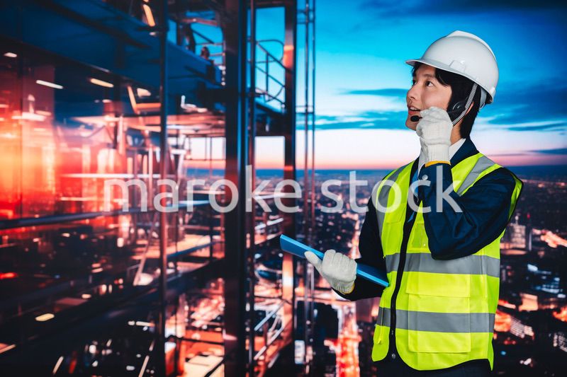 高層ビルの建築現場で作業をする若い男性