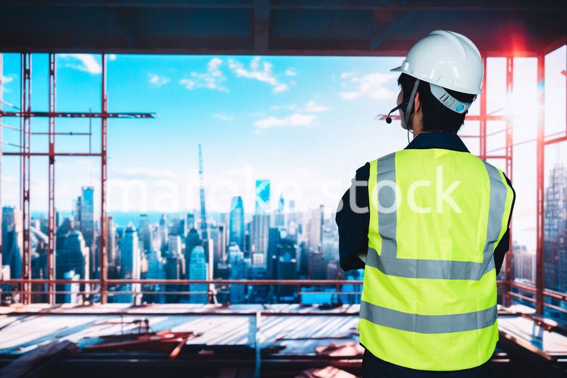 高層ビルの建築現場で作業をする若い男性