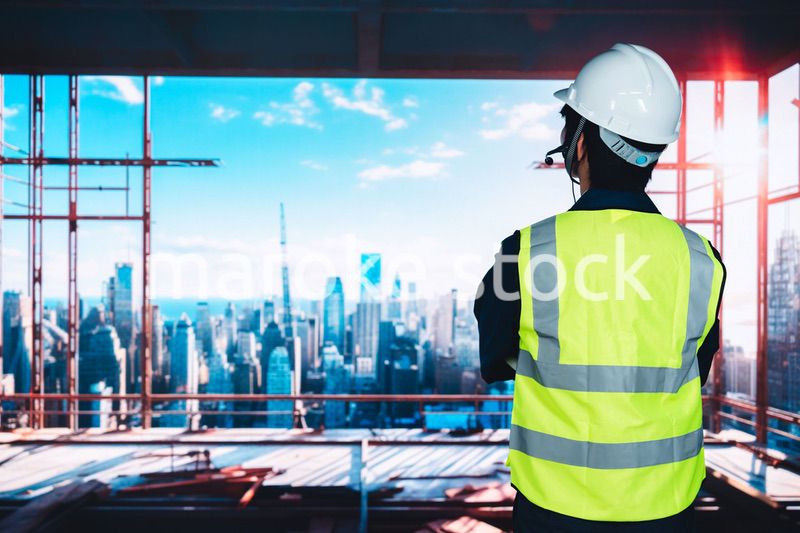 高層ビルの建築現場で作業をする若い男性