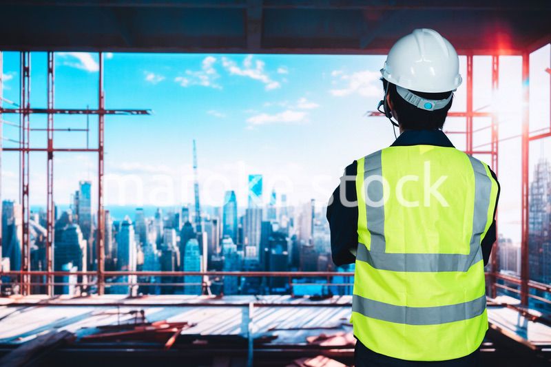 高層ビルの建築現場で作業をする若い男性