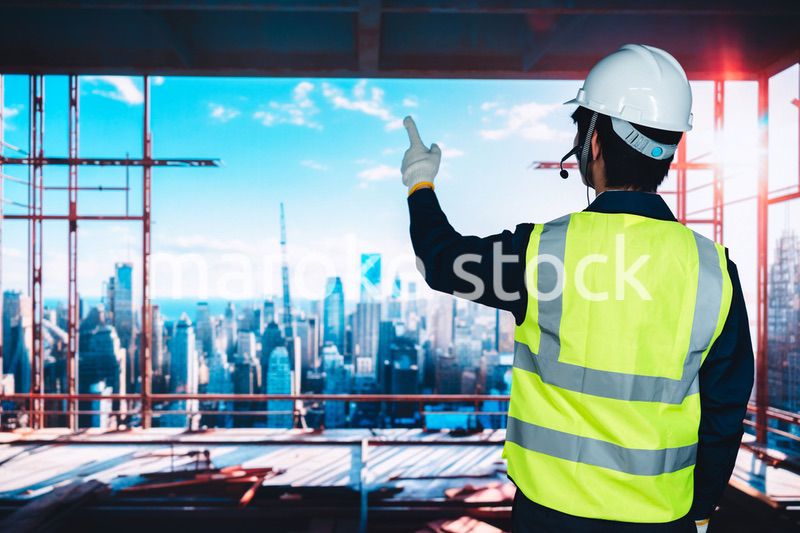 高層ビルの建築現場で作業をする若い男性