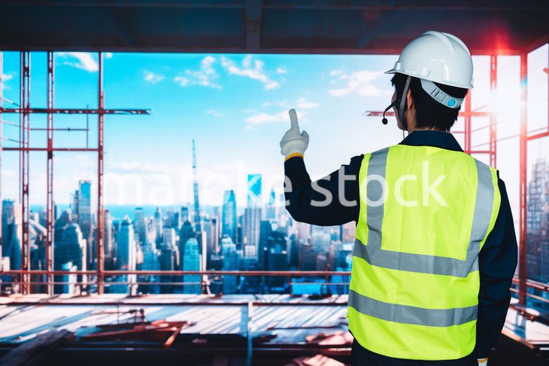 高層ビルの建築現場で作業をする若い男性