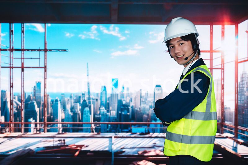 高層ビルの建築現場で作業をする若い男性