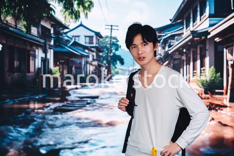 大雨で浸水した街から避難する男性