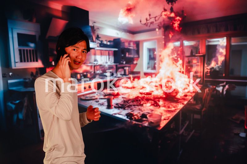 火事現場から消防に通報をする若い男性