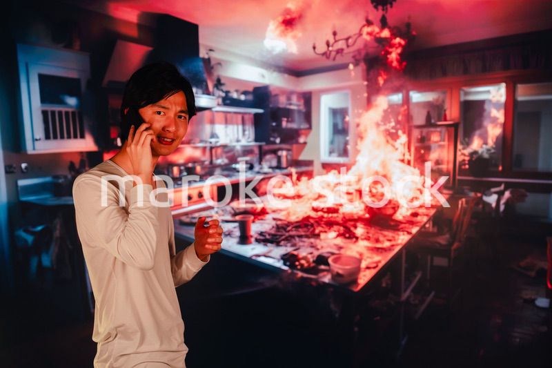 火事現場から消防に通報をする若い男性