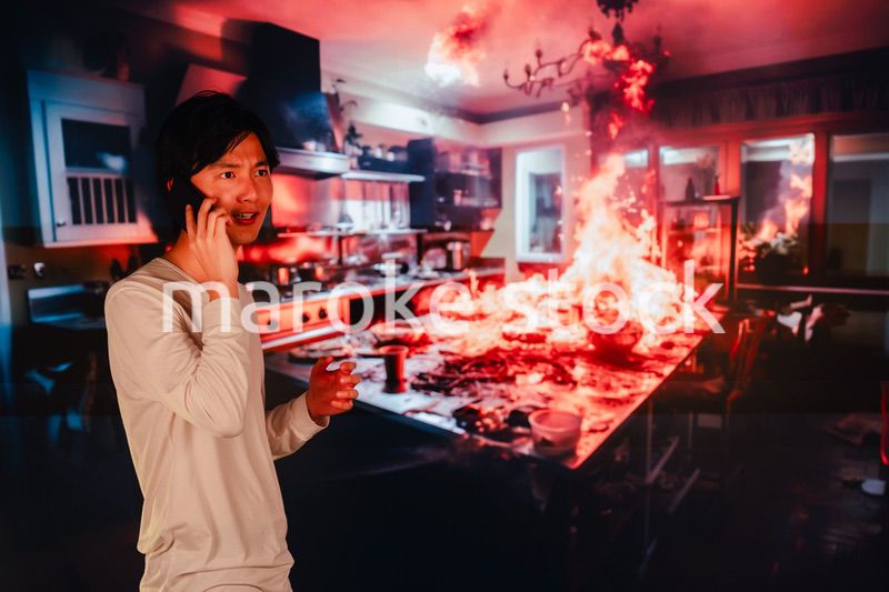 火事現場から消防に通報をする若い男性