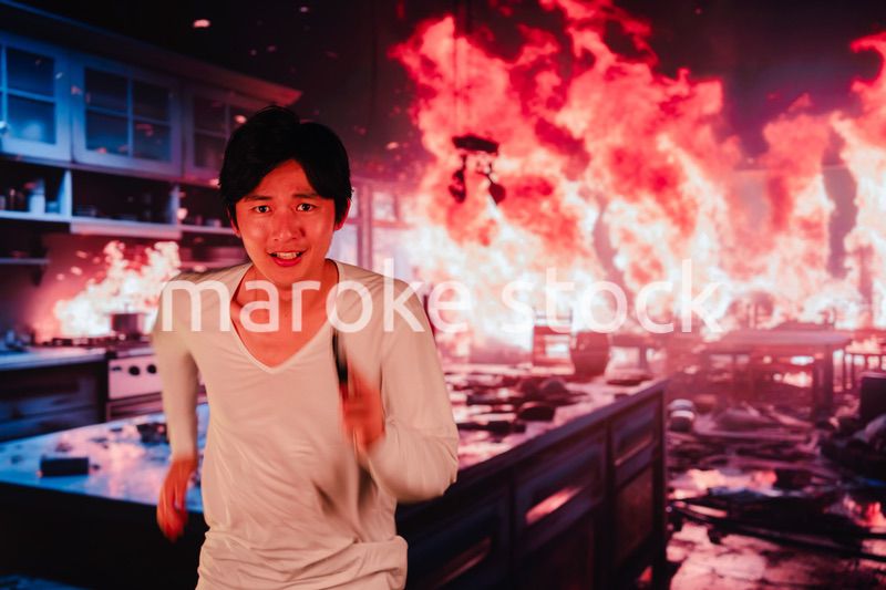 火災現場から走って逃げる若い男性