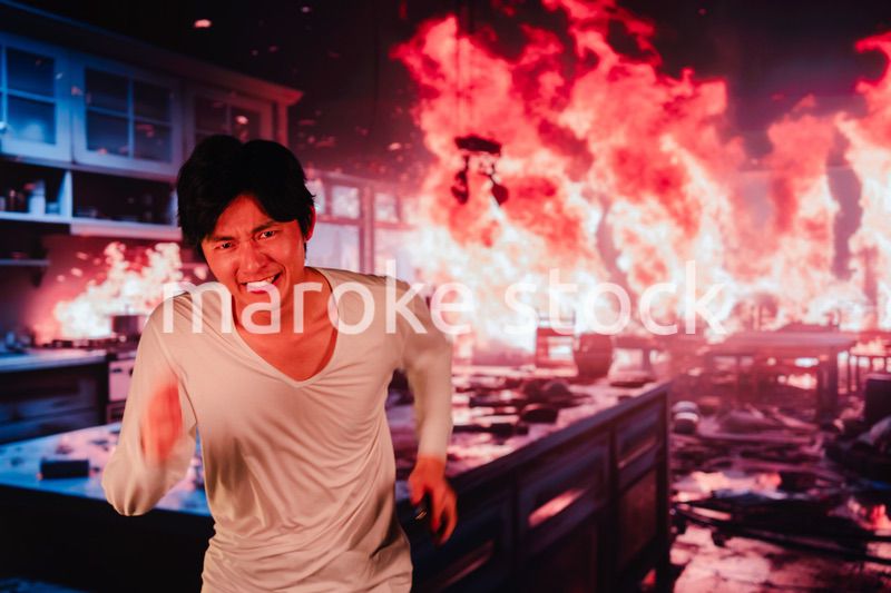 火災現場から走って逃げる若い男性