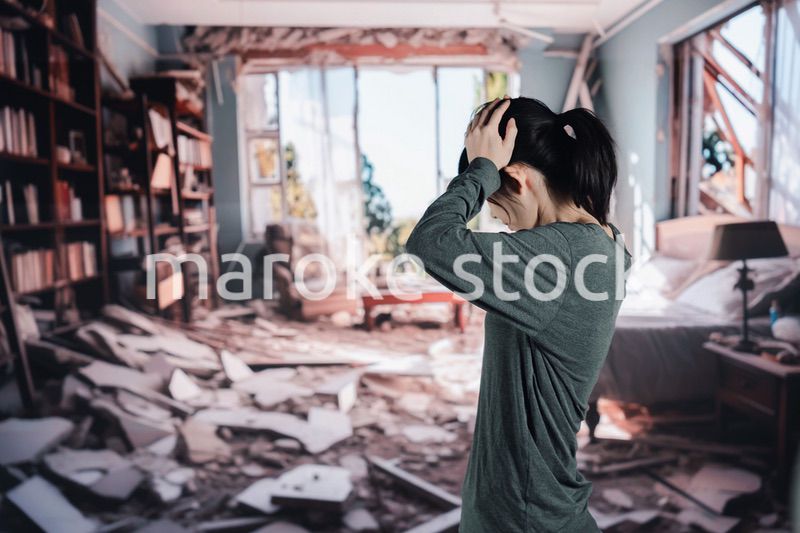 地震で家が倒壊して途方に暮れる女性
