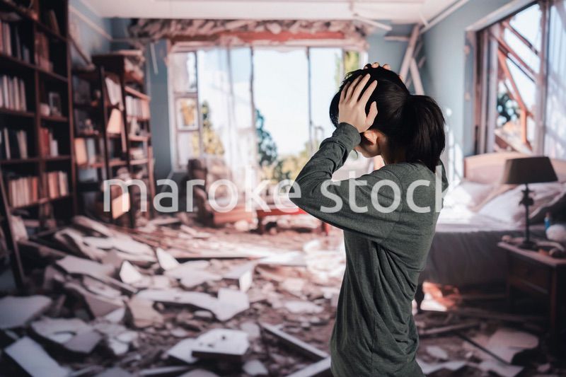 地震で家が倒壊して途方に暮れる女性