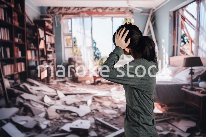 地震で家が倒壊して途方に暮れる女性