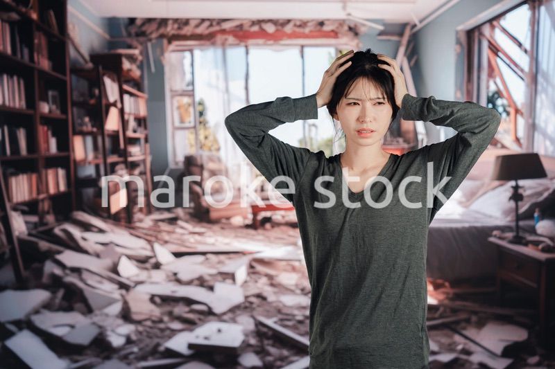 地震で家が倒壊して途方に暮れる女性