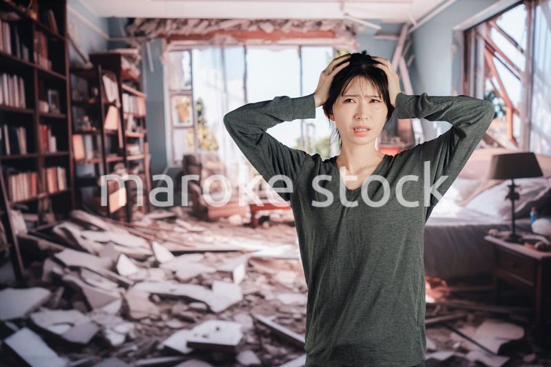 地震で家が倒壊して途方に暮れる女性