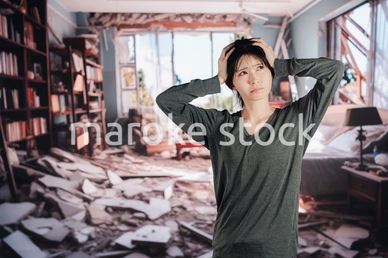地震で家が倒壊して途方に暮れる女性