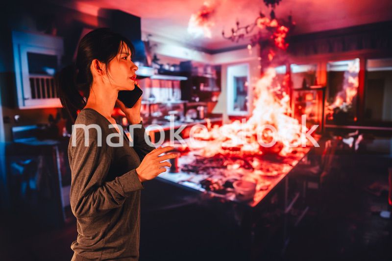 火災が発生し消防に通報をする若い女性