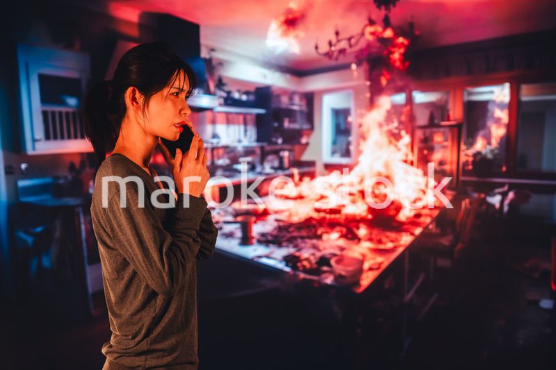 火災が発生し消防に通報をする若い女性