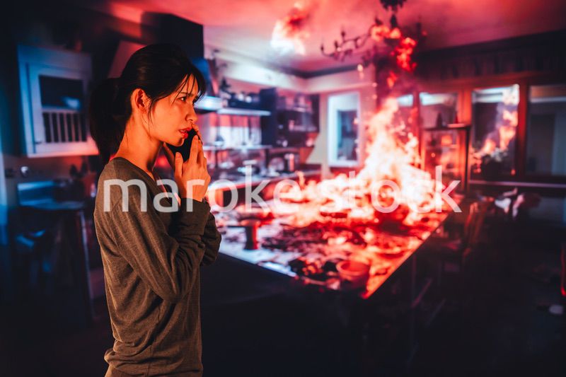 火災が発生し消防に通報をする若い女性