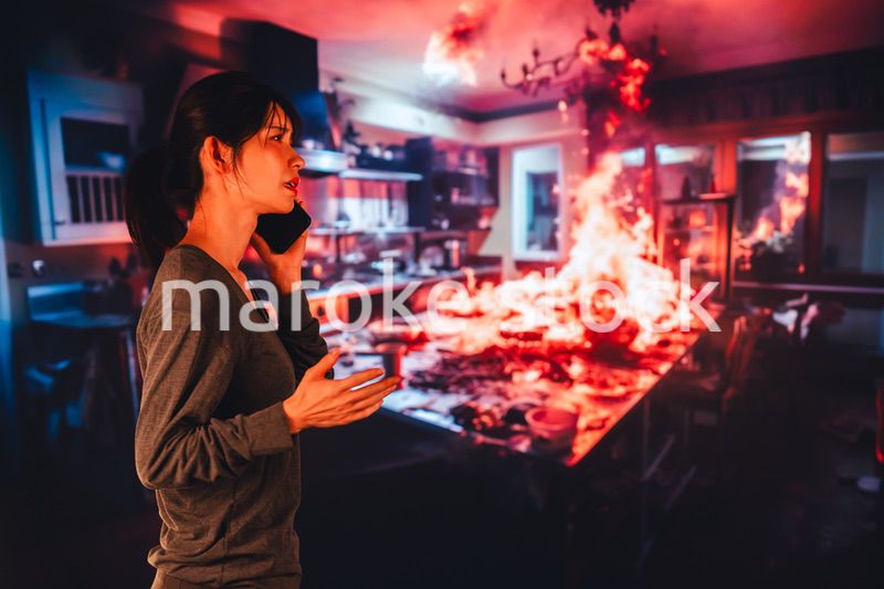 火災が発生し消防に通報をする若い女性