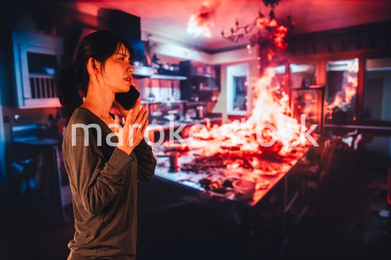 火災が発生し消防に通報をする若い女性