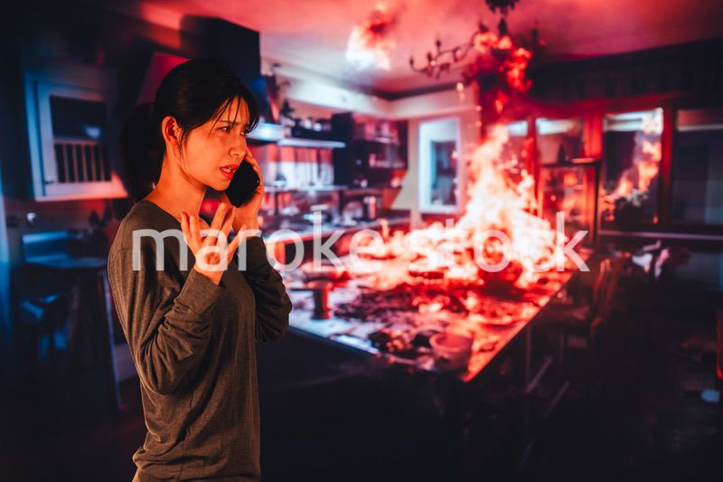 火災が発生し消防に通報をする若い女性