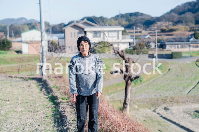 田舎の道を散歩する高齢の女性