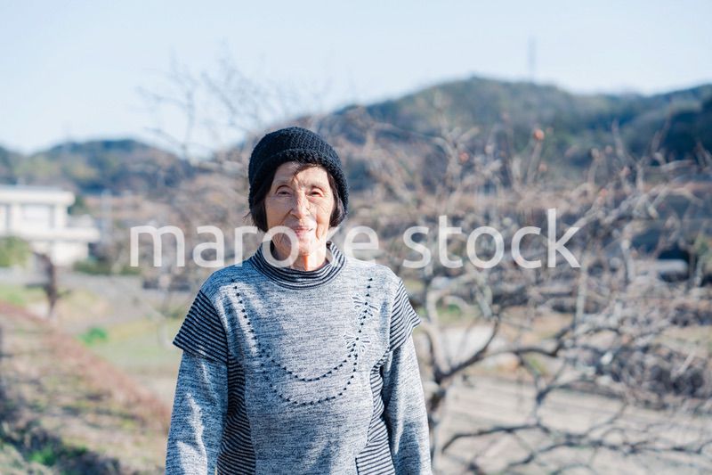 田舎の道を散歩する高齢の女性