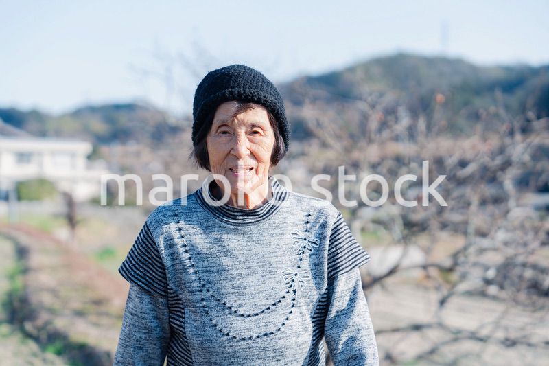 田舎の道を散歩する高齢の女性