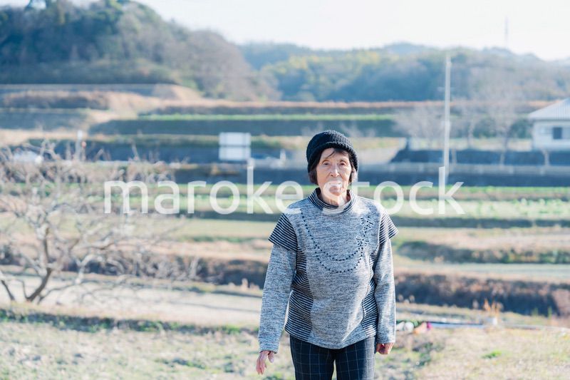 田舎の道を散歩する高齢の女性