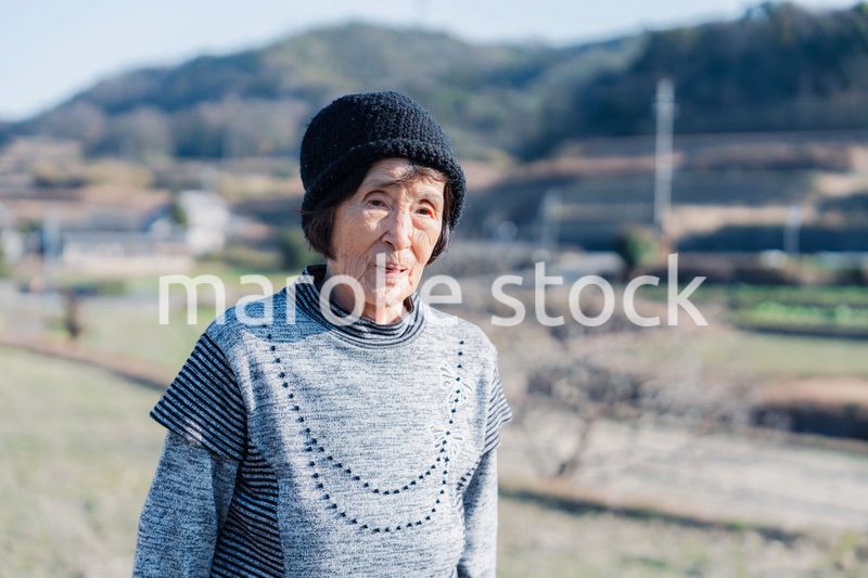 田舎の道を散歩する高齢の女性