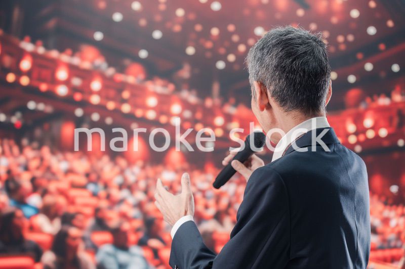大勢の聴衆の前で話す男性