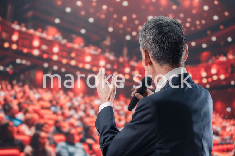 大勢の聴衆の前で話す男性