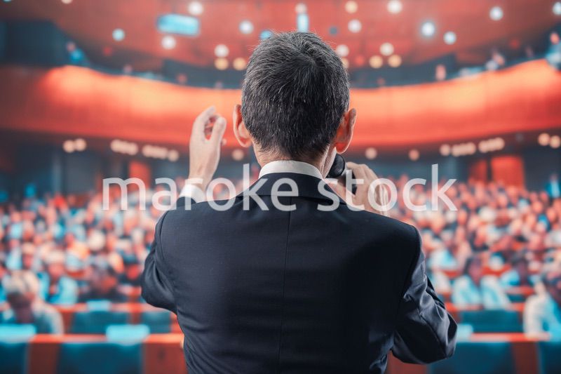 大勢の聴衆の前で話す男性