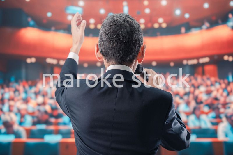 大勢の聴衆の前で話す男性